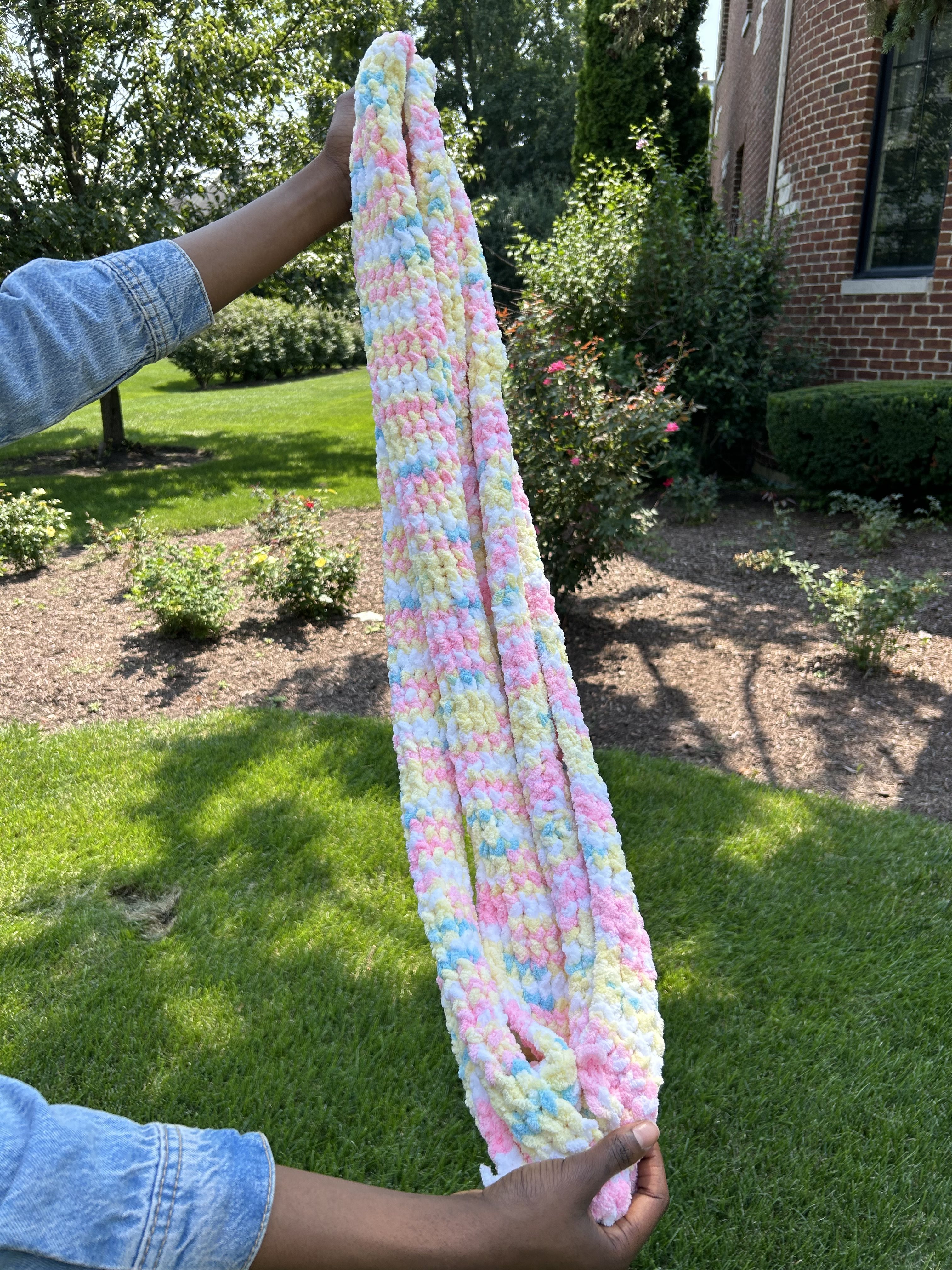 Chigo holding a handmade knit scarf
