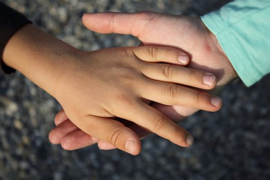 child's hand in adult's hand