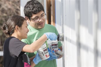 two students painting a wall
